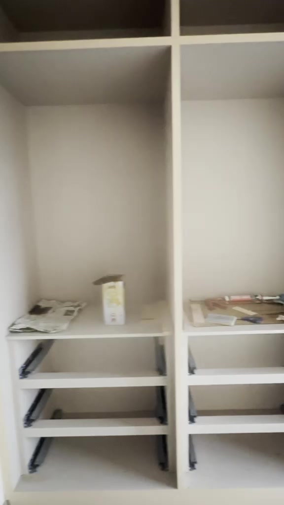Interior of a wardrobe carcass with black soft-close drawer runners fitted to both bays